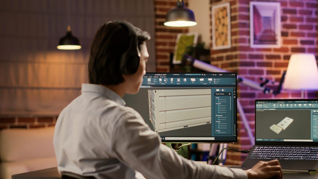 Asian technician using industrial software to create product component